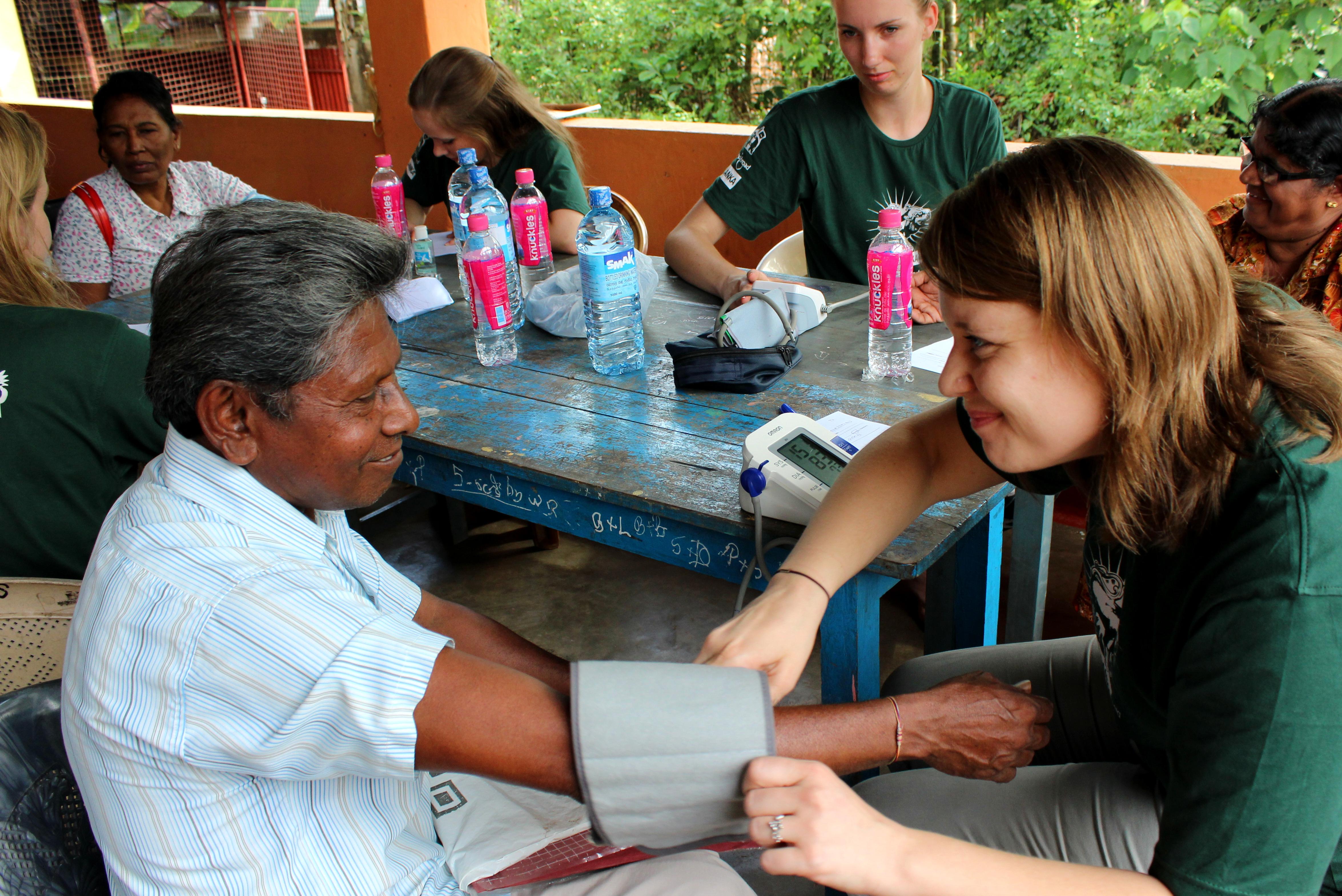 A Projects Abroad intern taking blood pressure tests suring a medical outreach whilst on her medical internship in Sri Lanka. A Projects Abroad female intern can be seen taking blood pressure tests during her medical internship in Sri Lanka.